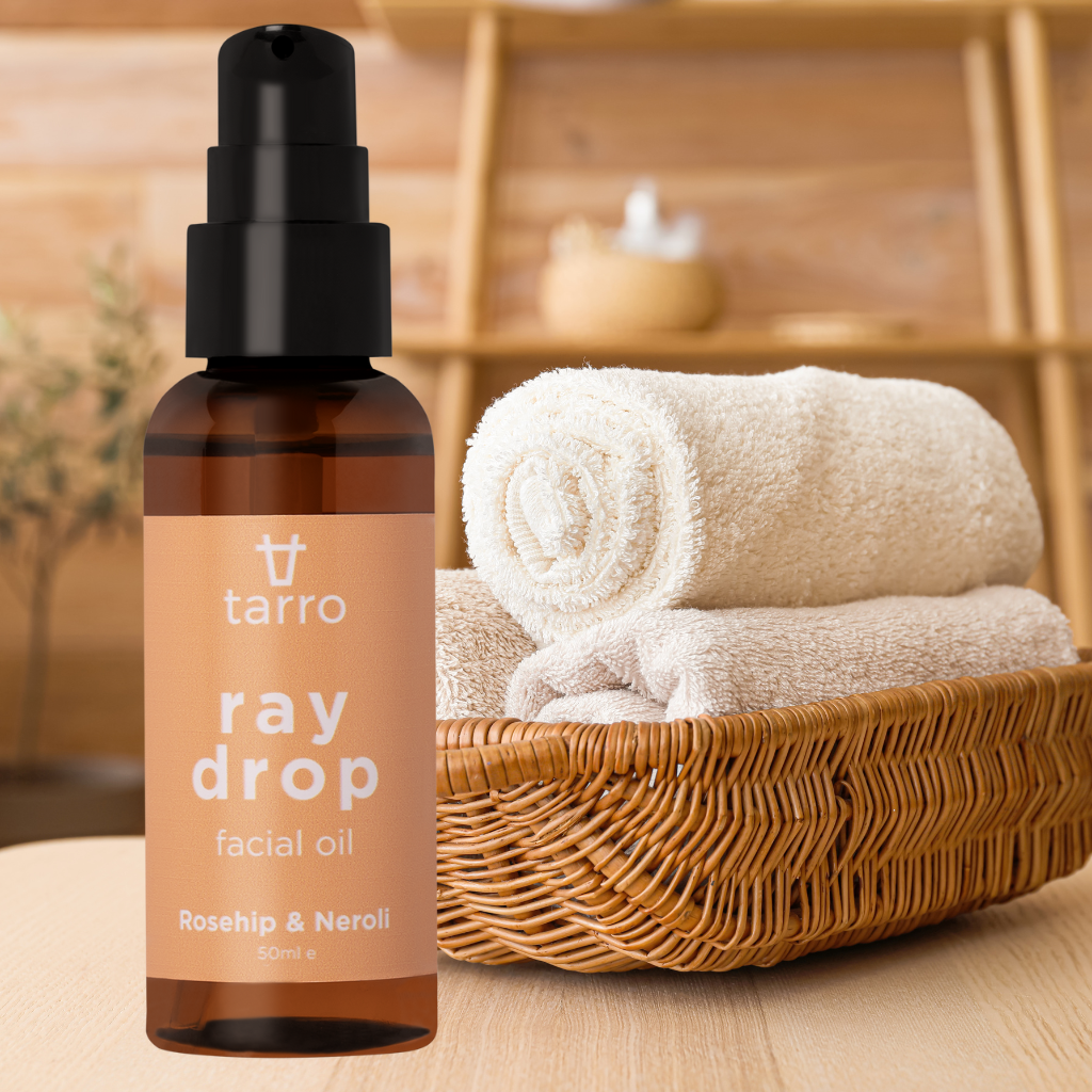 Bottle of tarro ray drop facial oil with towels in the background